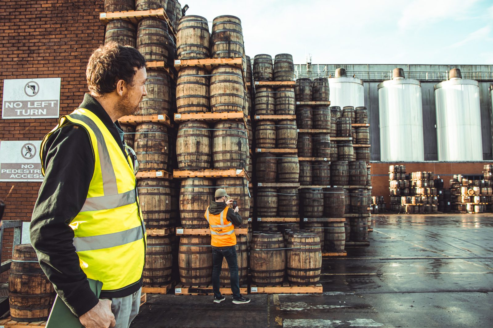 Patrick among the casks at the distillery, stainless fermenters behind